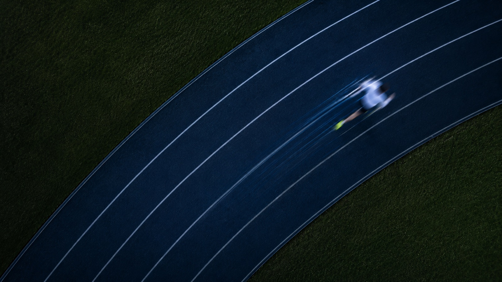 Runner on a curved running track with motion blur